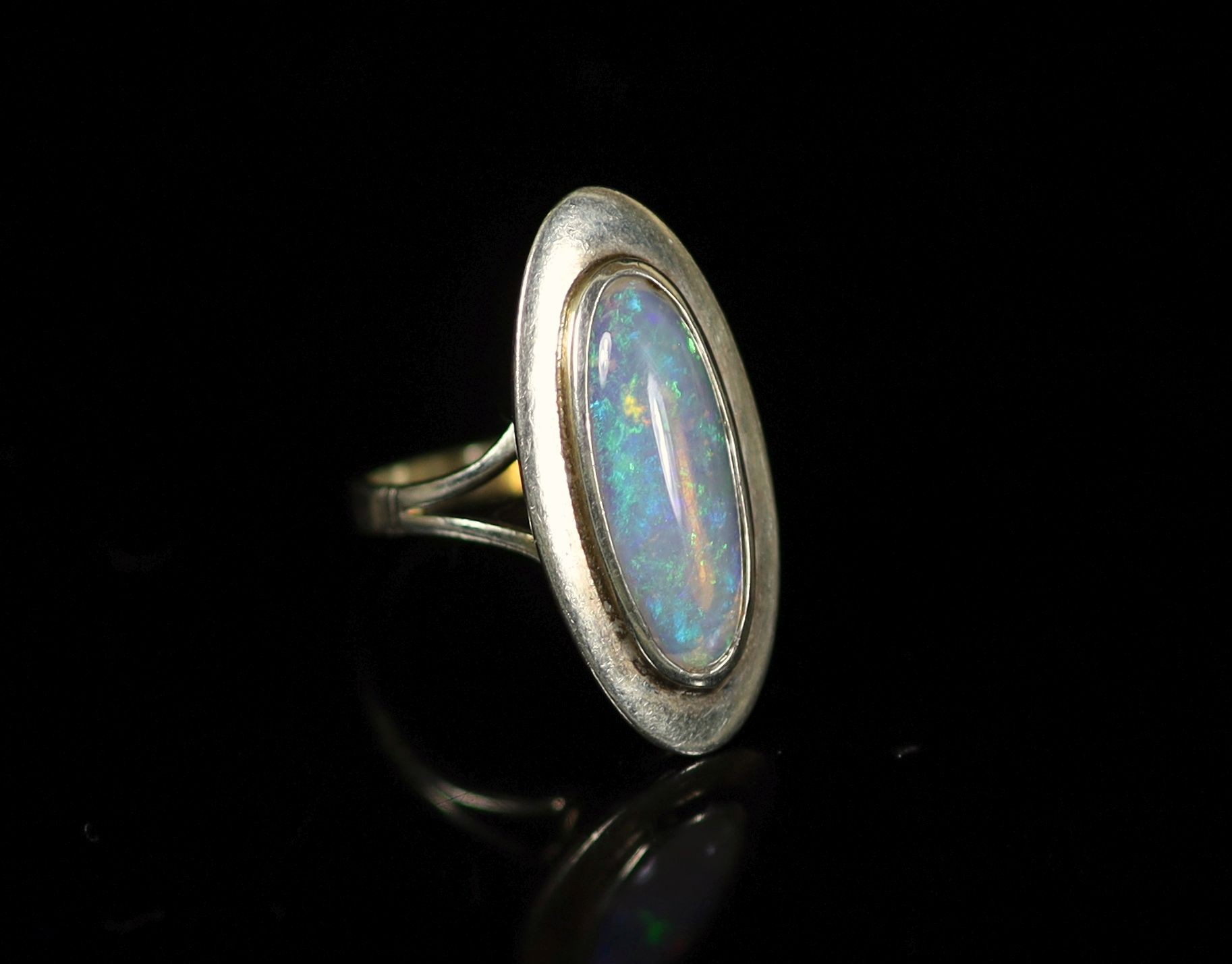 A 9ct white gold and oval cabochon white opal set dress ring